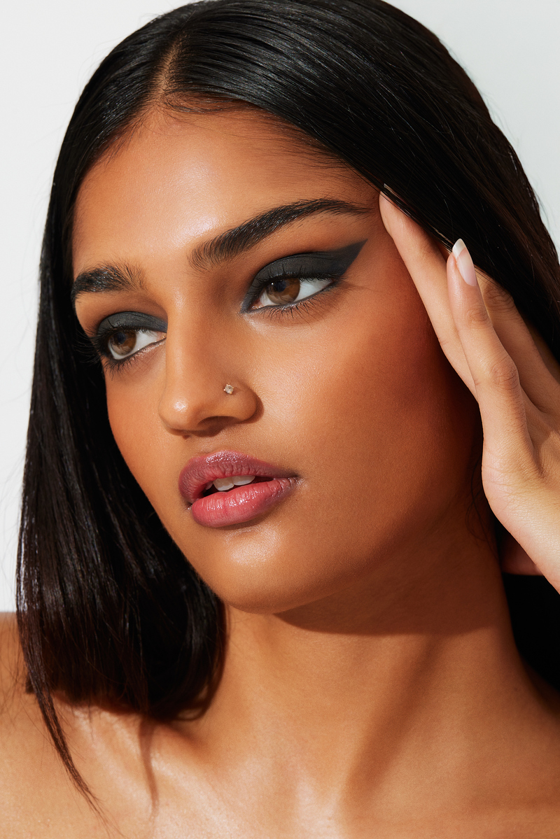 Close-up beauty portrait for Ecoglo Cosmetics featuring dramatic black winged eyeliner and glossy lips, photographed at Know Good Studio in Miami by Josh Eskridge