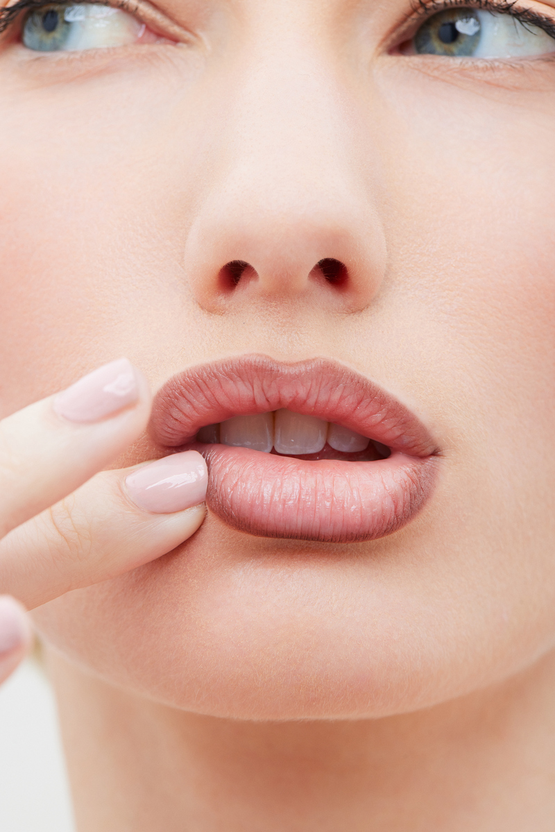 Close-up beauty image of a model wearing nude lipstick and pale pink nails for Ecoglo Cosmetics, photographed in Miami by Josh Eskridge