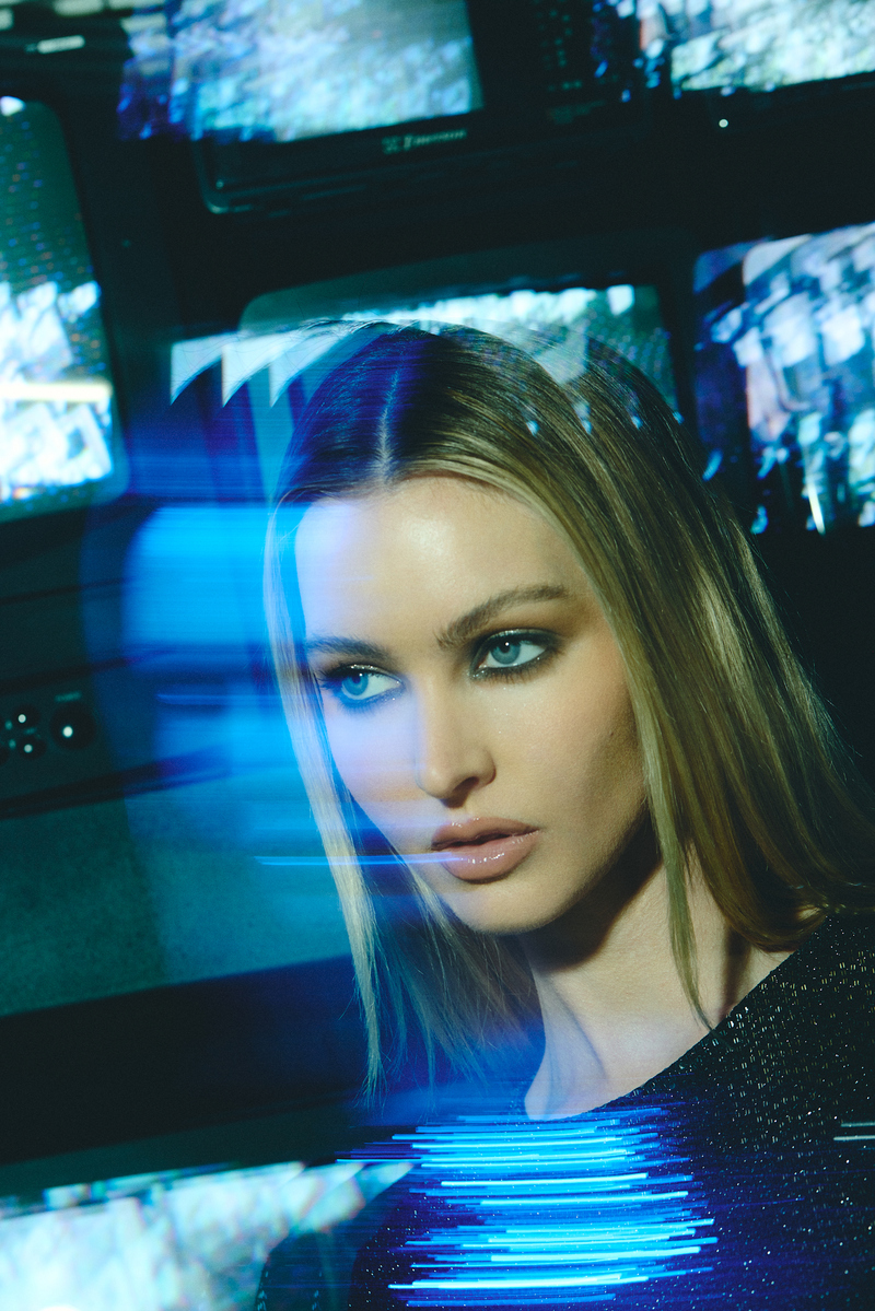 Editorial beauty portrait of model Laken Romine with glossy makeup and blue cinematic reflections, photographed at the vintage TV wall inside Know Good Studio in Miami by Josh Eskridge